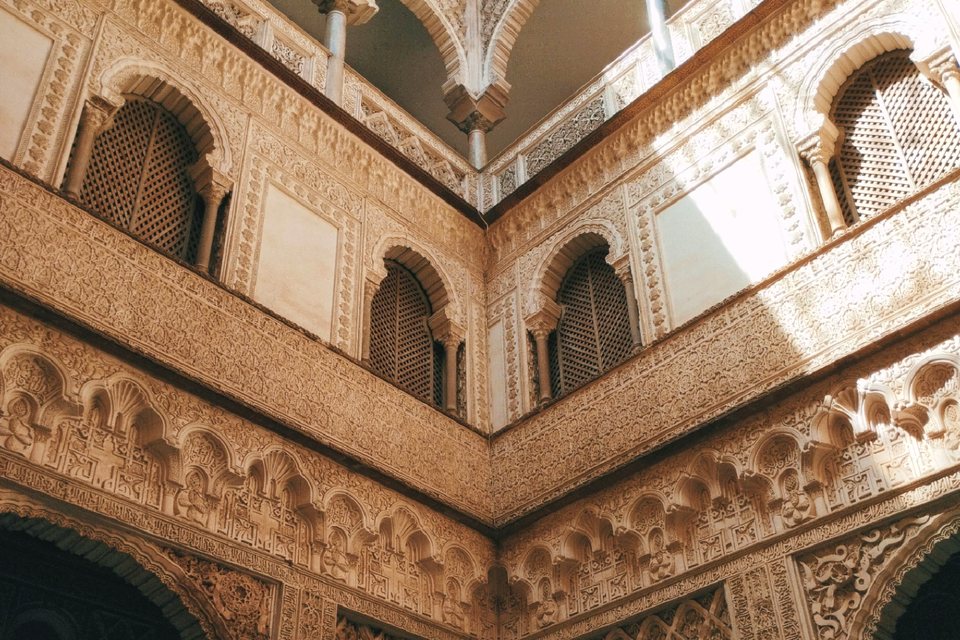 Sunlit Islamic arches and carved geometric plasterwork